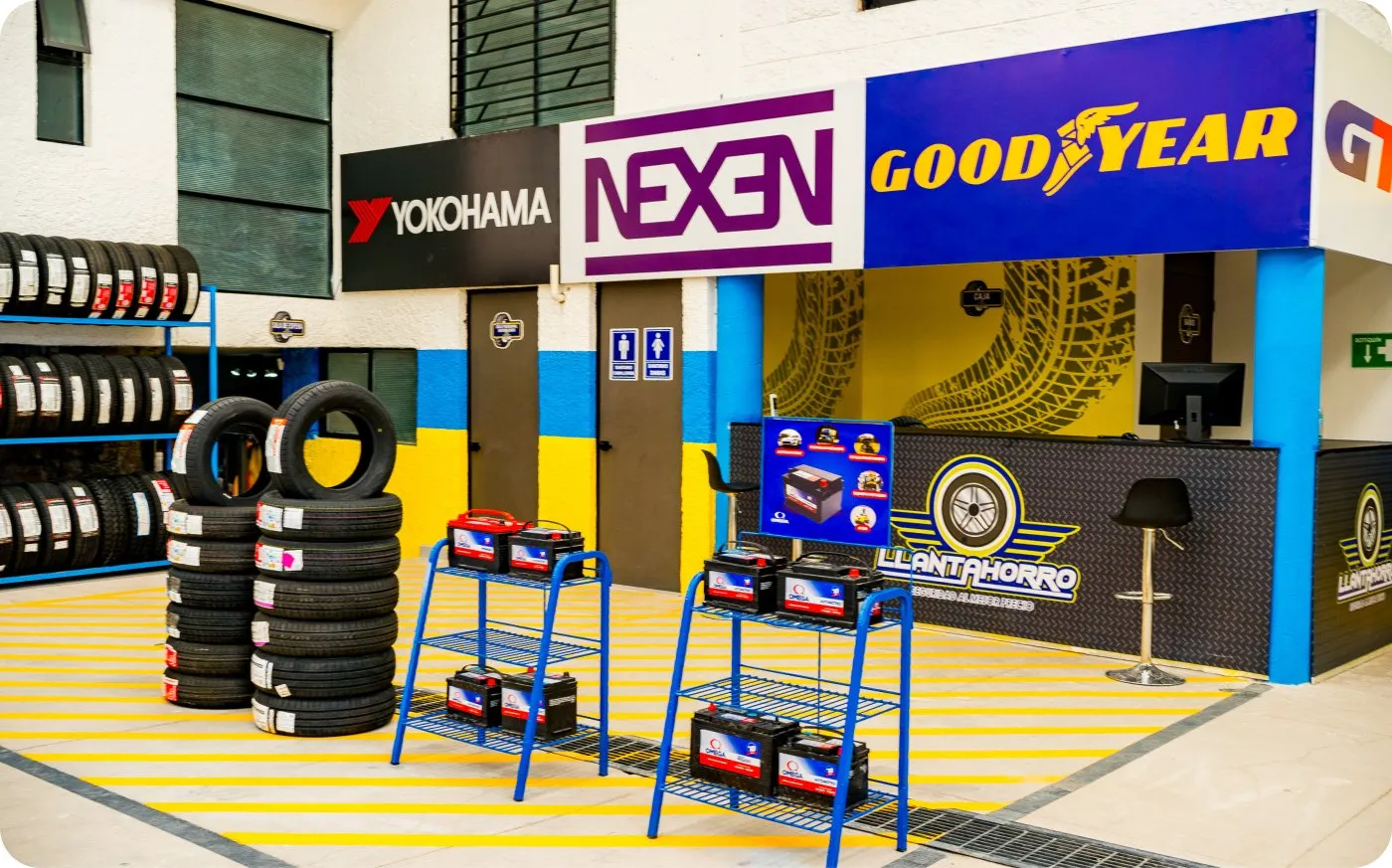 Interior de una llantera Llantahorro con exhibición de llantas y marcas